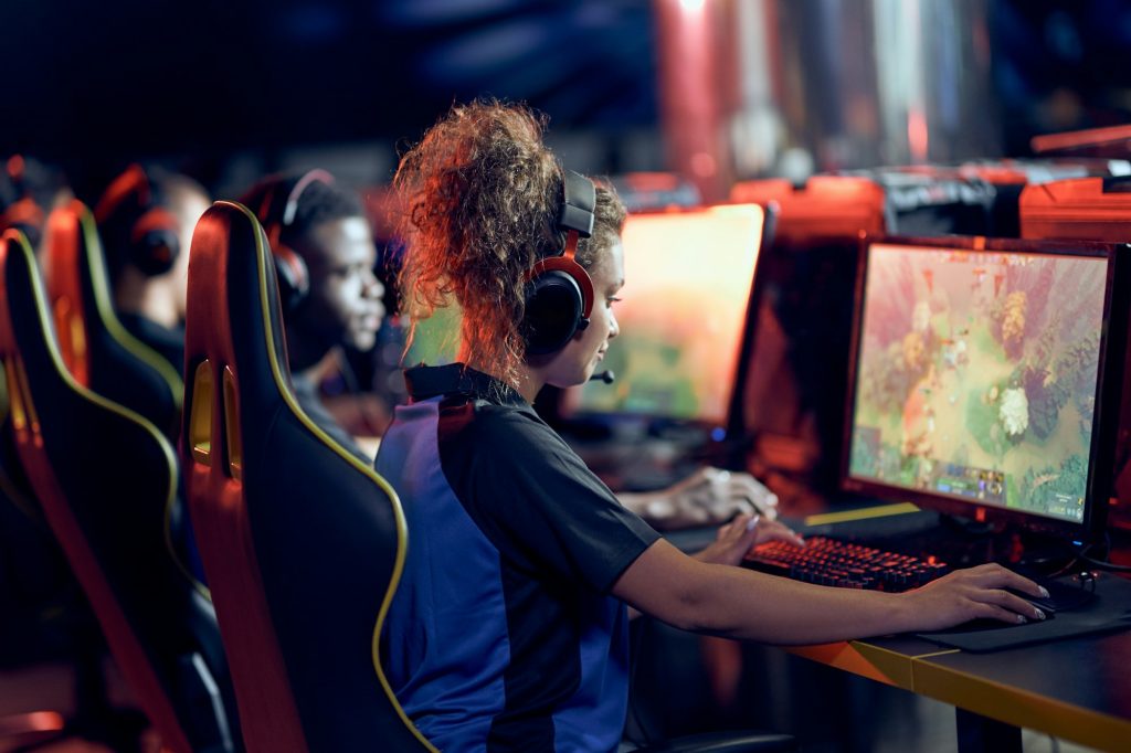 Team of professional gamers participating in global eSport tournament, side view. Mixed race teenage